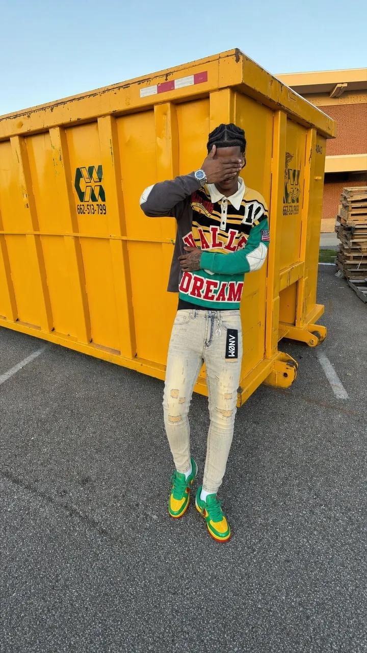 ANØM DENIM light-wash skinny jeans on model by a yellow dumpster